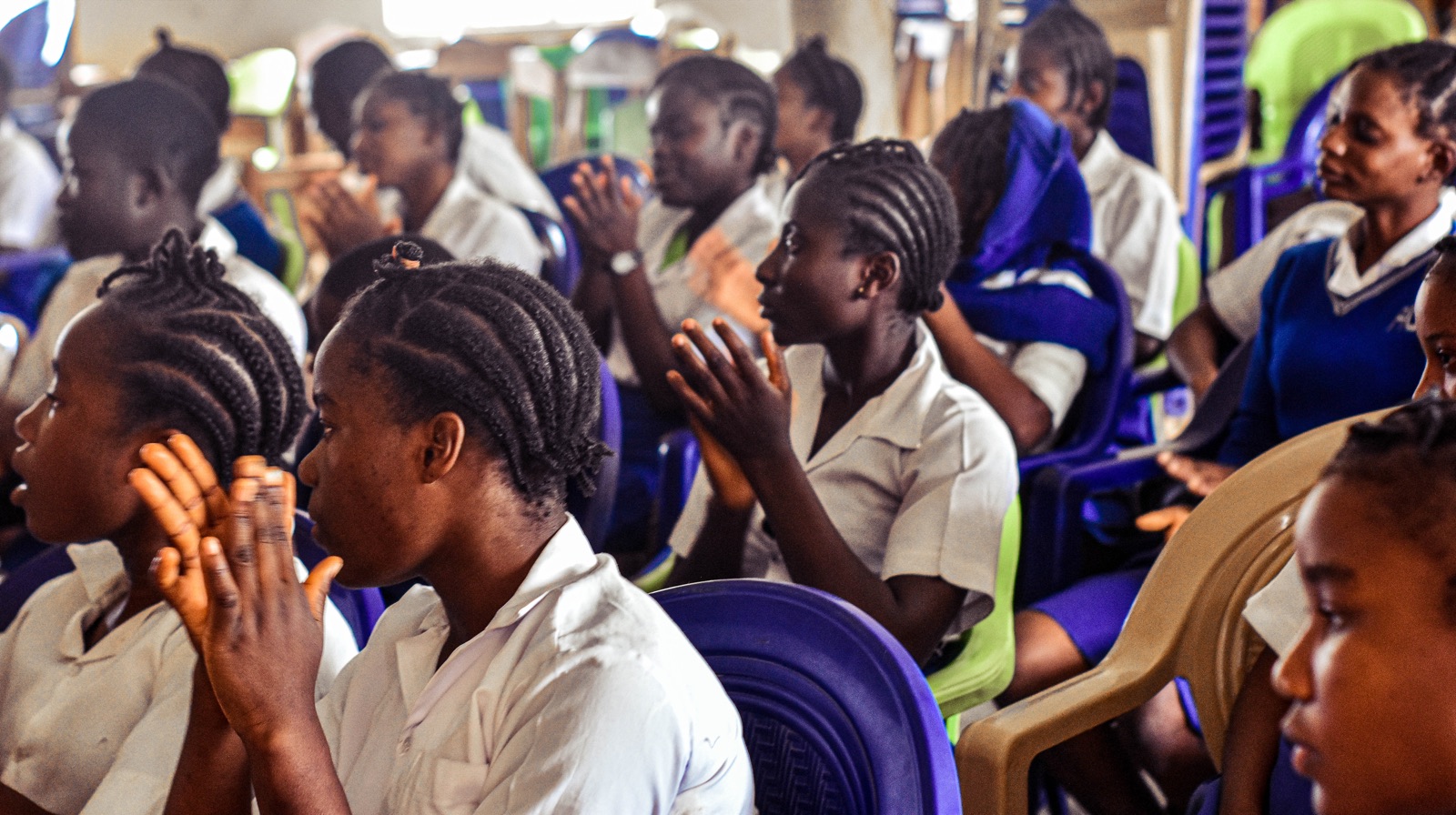 Students clapping and smiling during an outreach session